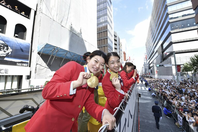パレードで金メダルをカメラに向けるタカマツ　©JMPA
