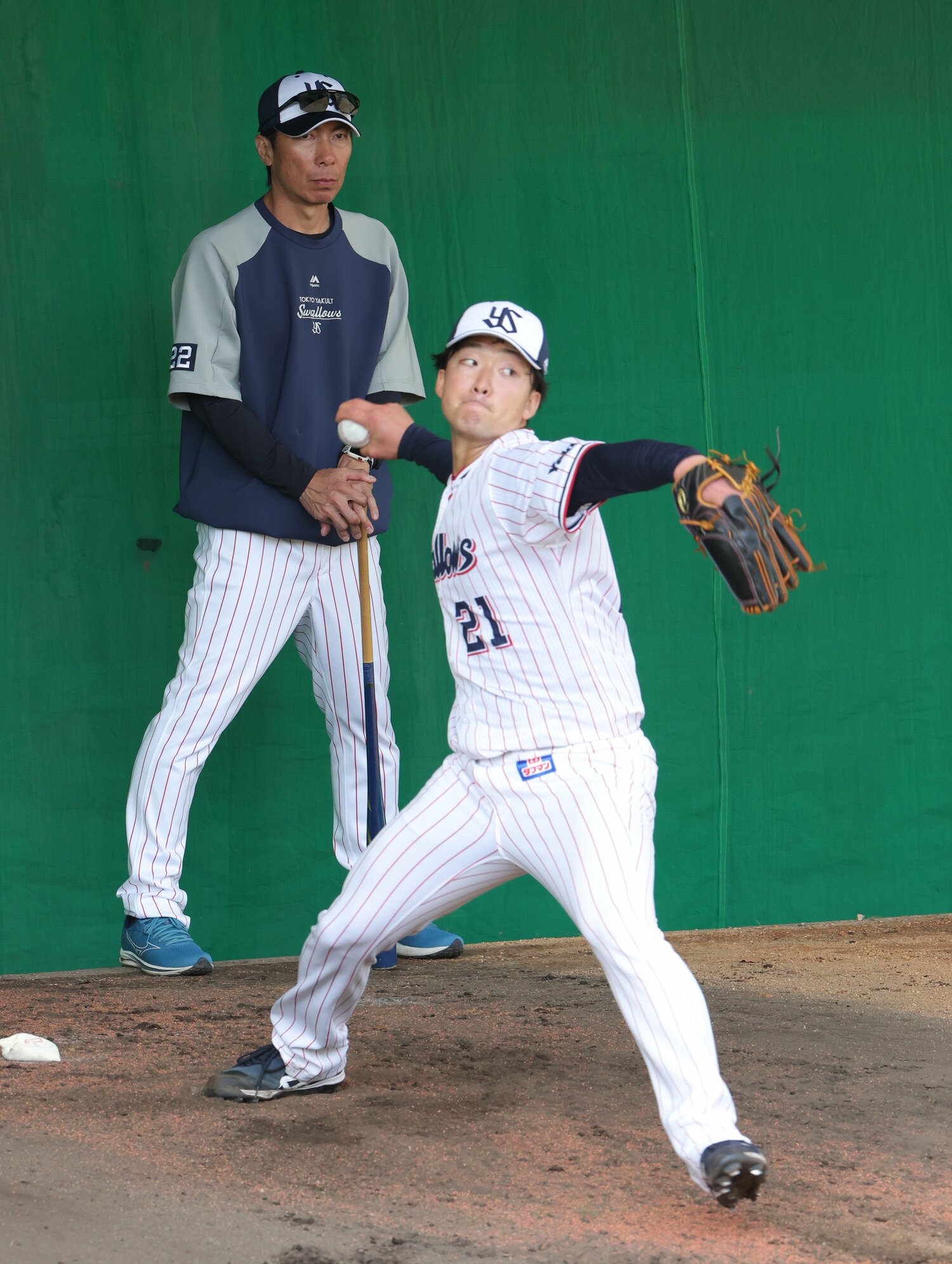 浦添キャンプ、ブルペンで投球練習するルーキー吉村貢司郎。後ろで高津監督が見守る ©JIJI PRESS