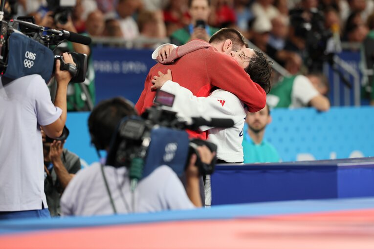 試合を終えコーチと抱き合う出口　©Kaoru Watanabe/JMPA