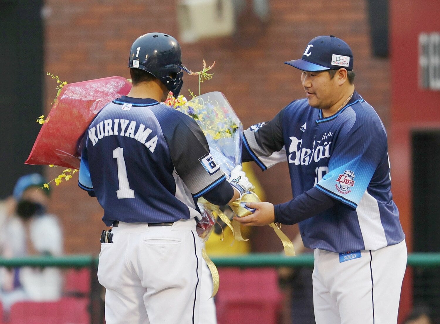 2021年に2000本安打を達成し、中村剛也(右)から花束をもらう栗山巧 ©JIJI PRESS