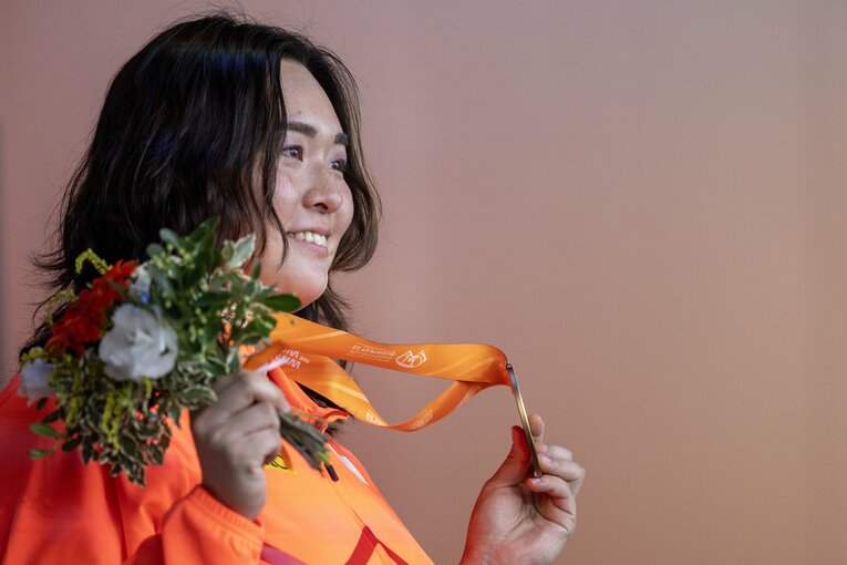 髪をおろしたスタイルで金メダルを掲げる北口　©︎Getty Images