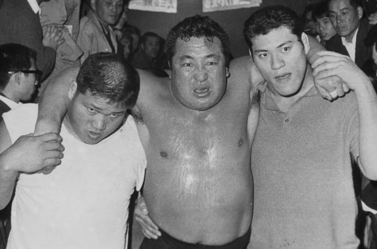 力道山vsデストロイヤー。豊登（左）と アントニオ猪木（右）に助けられ、会場を後にする力道山 ／ photograph by Sankei Shimbun
