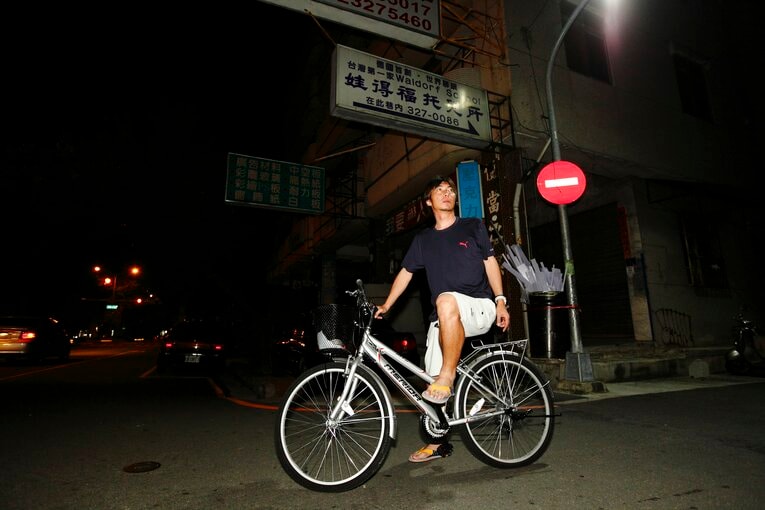 台湾時代、自転車に乗る高津　©BUNGEISHUNJU