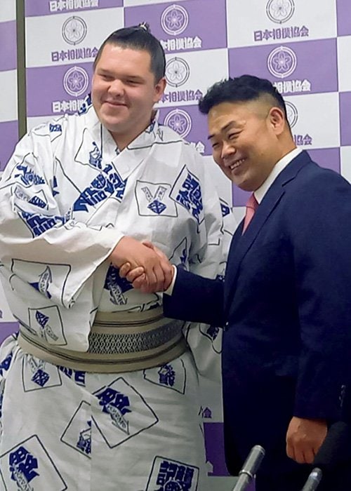 師匠の雷親方と握手する獅司（左）。自己最高位だった西幕下二枚目の夏場所を6勝1敗とし、新十両をつかんだ