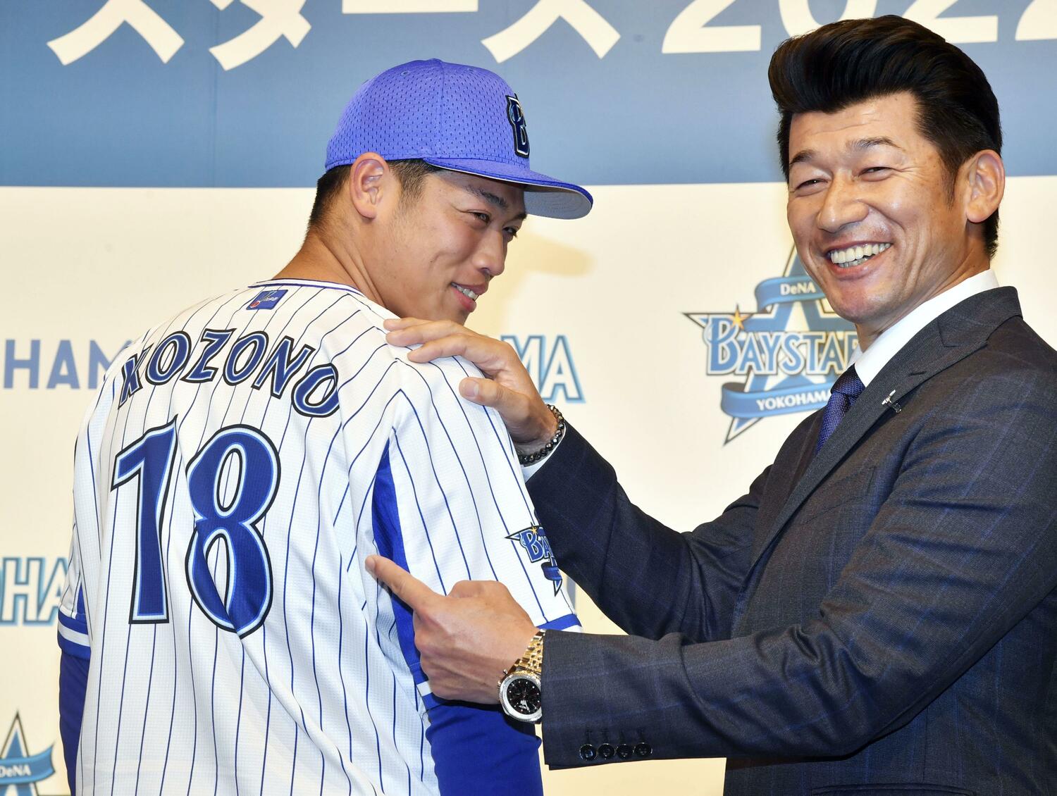 昨年12月の入団発表で背番号18を披露した小園。番号からも三浦監督の表情からも期待の大きさが伝わる ©KYODO