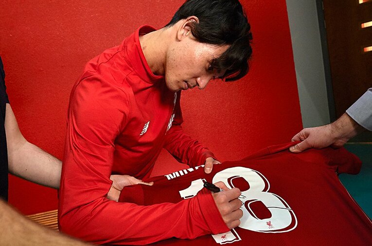 リバプールで背負う「18番」にサインする南野拓実。カイトら名選手がつけた番号を、自分の色に染めてほしい。 ／ photograph by Getty Images