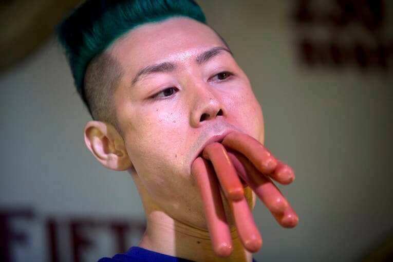 ロングソーセージを7本咥える小林尊（2014年）　©AFLO