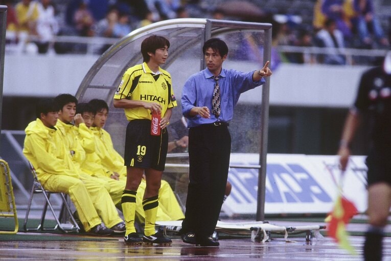 西野朗監督（右）から指示を受ける若き日の北嶋秀朗（1998年）©︎J.LEAGUE