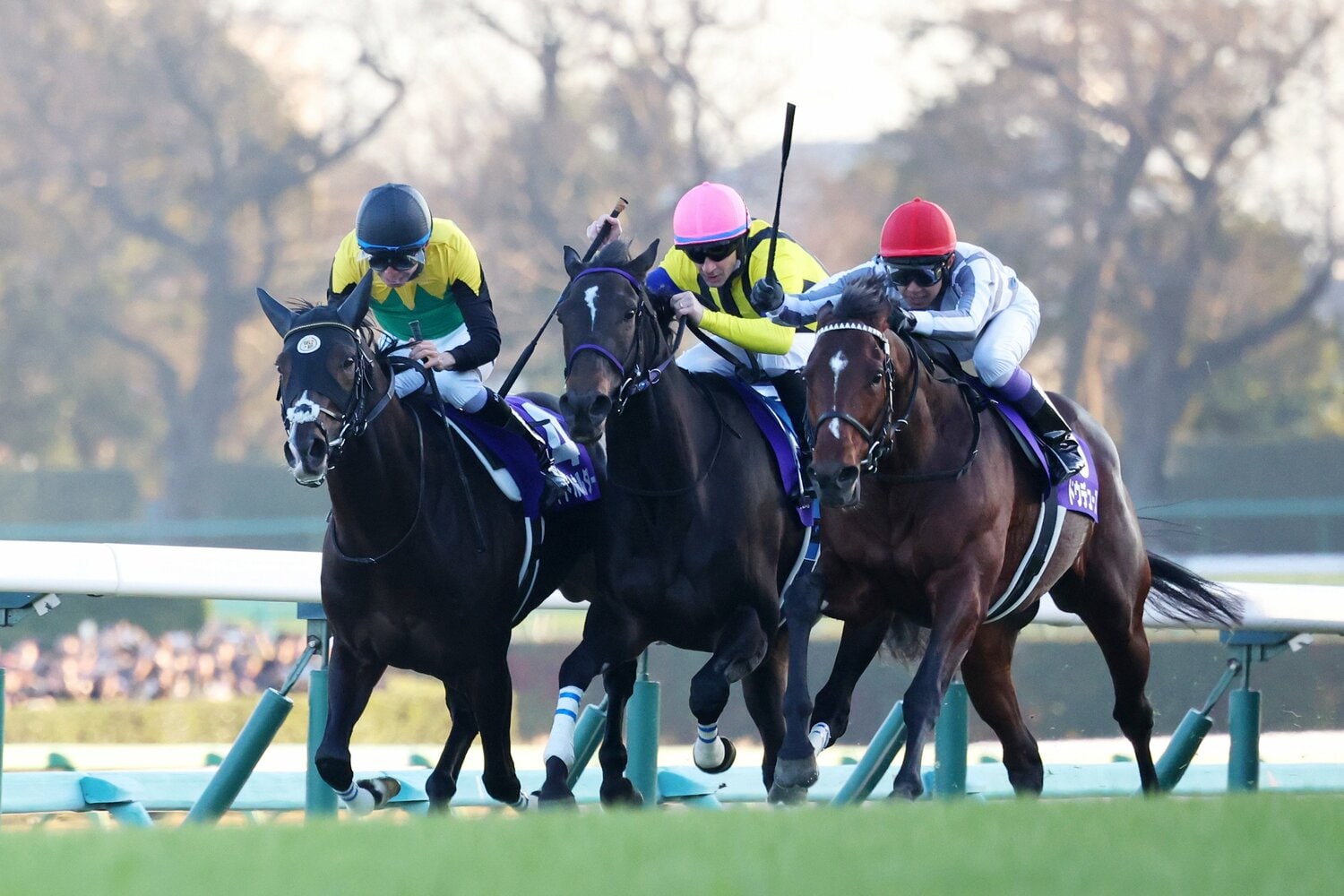 直線の攻防。ドウデュースはスターズオンアースと競り合いながら、タイトルホルダーに襲いかかる　©JIJI PRESS