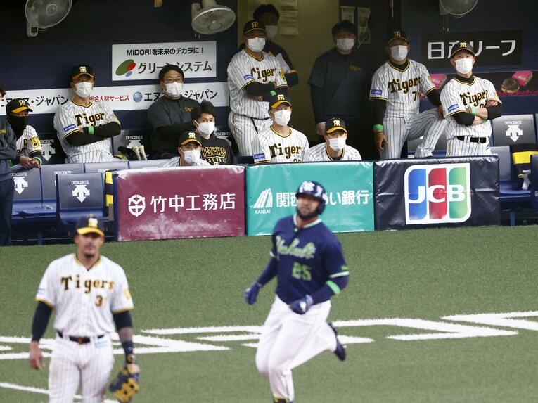 開幕戦9回、サンタナ（手前右）が決勝の2ラン（10対8）。静まりかえる阪神ベンチ　©KYODO