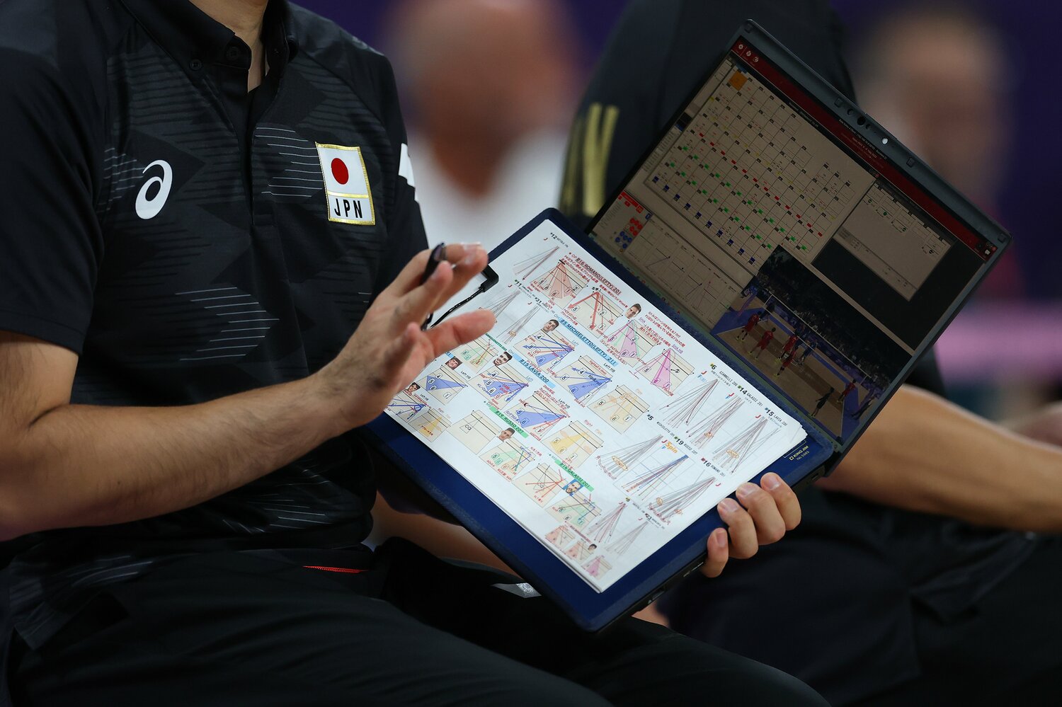 日本の緻密な戦術と遂行力。行武アナリストが手にする資料を狙うカメラマンもいた　©︎Carl Recine/Getty Images