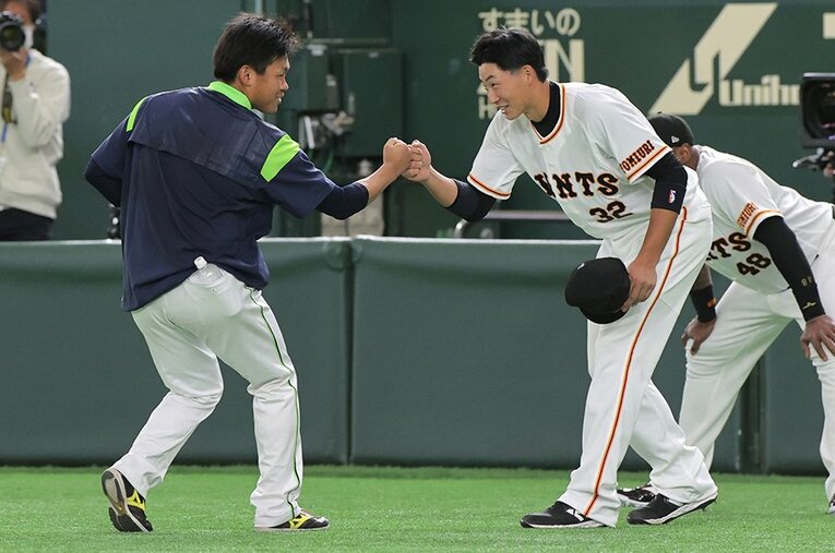 お互いの健闘を称えてグータッチする田口麗斗と廣岡大志。巨人とヤクルトの有望株とされていた2人の電撃トレードは、どんな結果をもたらすか ／ photograph by Sankei Shimbun