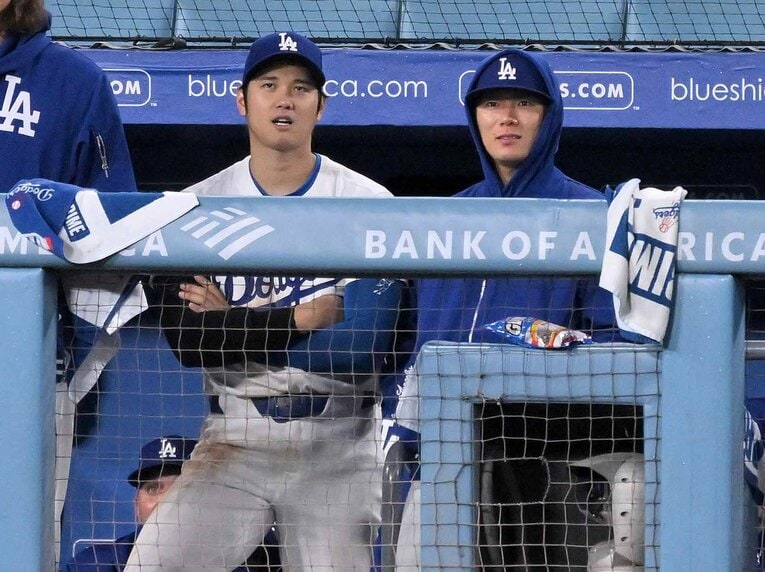 ベンチで会話する大谷と山本　©JIJI PRESS