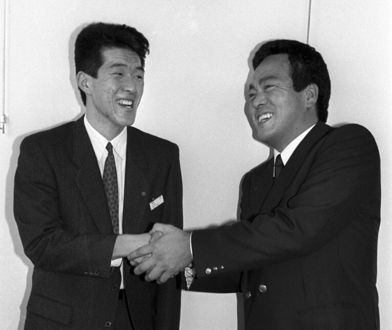 NTT中国から広島への入団内定が決まった佐々岡真司（左）。球団スカウトと笑顔で握手　©KYODO