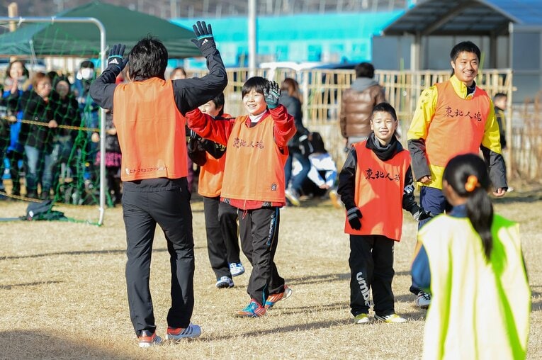 東北人魂が主催したサッカー教室に参加した小学生時代の菅原。柴崎岳とハイタッチしている少年が菅原だ（写真は2013年の開催時）©︎Miki Sano