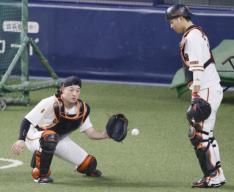 守備練習をする岸田行倫（左）と大城卓三　(C)KYODO