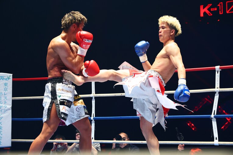 軍司泰斗にミドルキックを放つ門口佳佑　©RISE/Chiyo Yamamoto