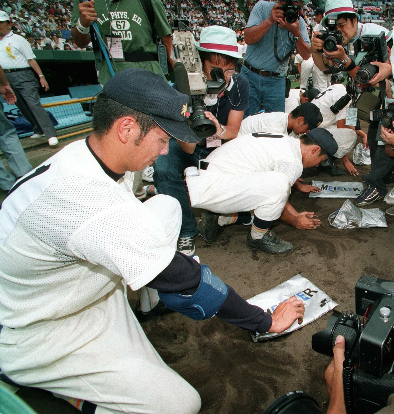 1998年夏の甲子園。1回戦で埼玉栄に敗れ、甲子園の土を袋につめる新垣渚 ©JIJI PRESS