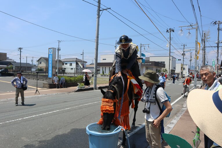 宵乗り行列中に水飲み場で水分補給をするナイトアンジェロ