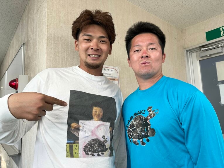 幼少期の写真を使った貴重な「リトル牧秀悟Tシャツ」を着る井上　©Chiba Lotte Marines