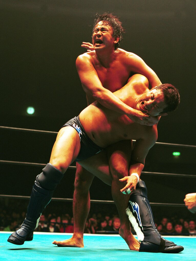 裸足の西村修が永田裕志をコブラツイストに捕える。2003年2月2日　©Essei Hara