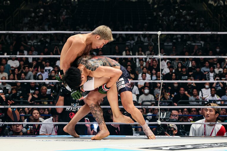 パンチに合わせたタックルでテイクダウンを許した秋元だが、スタンドに戻してみせた　©RIZIN FF Susumu Naga