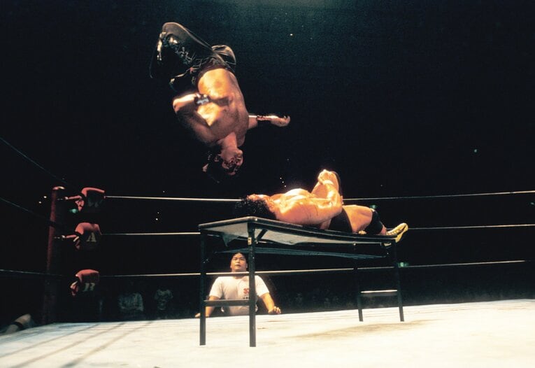 机上の天龍へムーンサルト・プレスを放つムタ