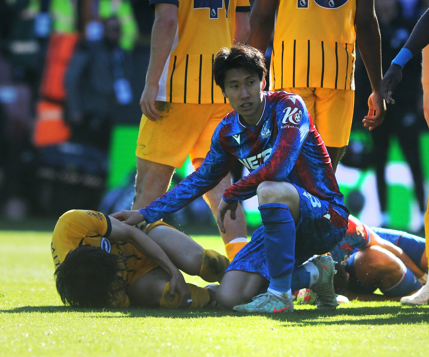 起き上がれない三笘のもとへ駆け付けた鎌田大地。心配そうな表情を浮かべる【1枚目／全3枚】　©AFLO