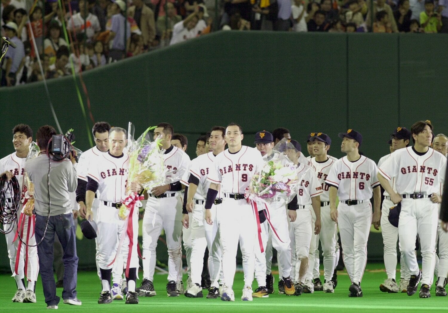 2001年9月30日、長嶋監督退任セレモニー。グラウンドを一周する長嶋監督、村田真一(中央)とナイン。その後ろに原辰徳・次期監督 ©JIJI PRESS