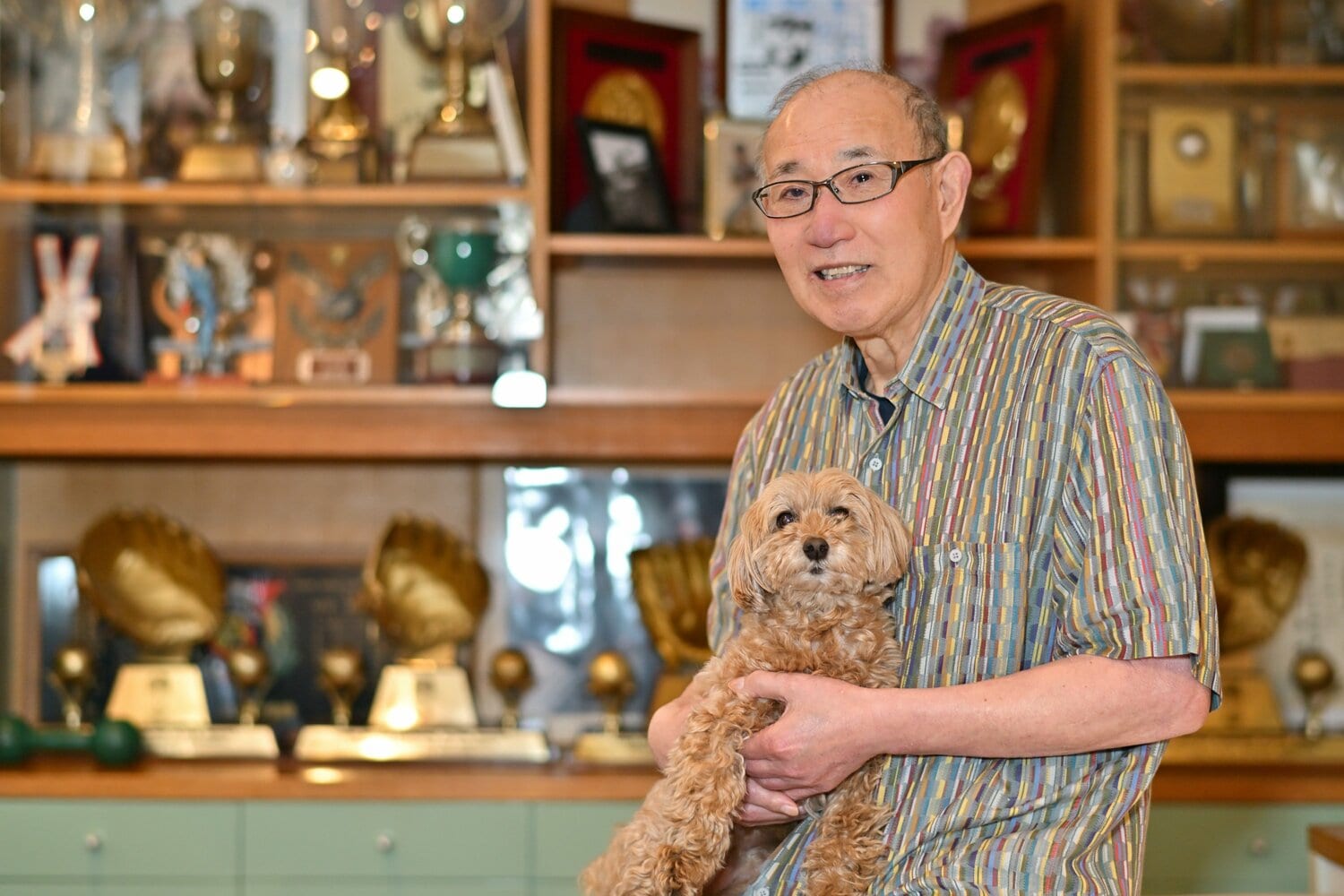 愛犬を抱いて表情をほころばせる現在の西本 ©Hideki Sugiyama