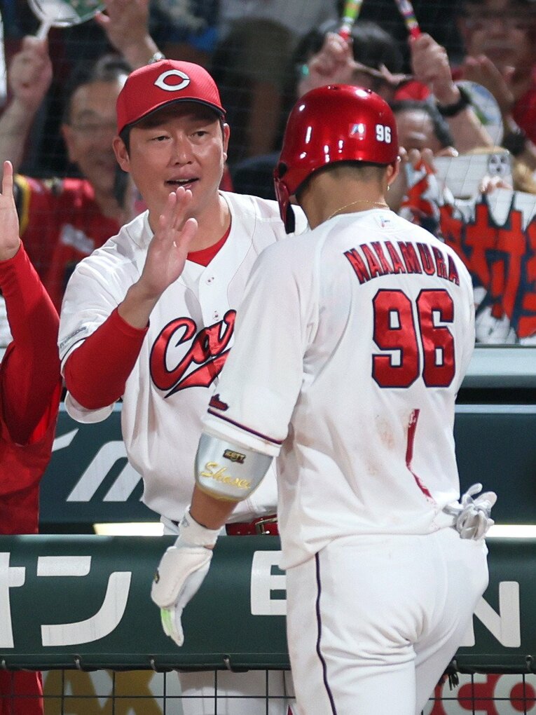 本塁打を放った中村奨を迎え入れる新井監督　©JIJI PRESS