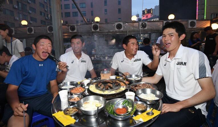 U-18W杯で焼肉店を訪れ決起集会。（左から）飯塚脩人に肉を食べさせる奥川恭伸、宮城大弥は佐々木朗希に…　©︎SANKEI SHIMBUN