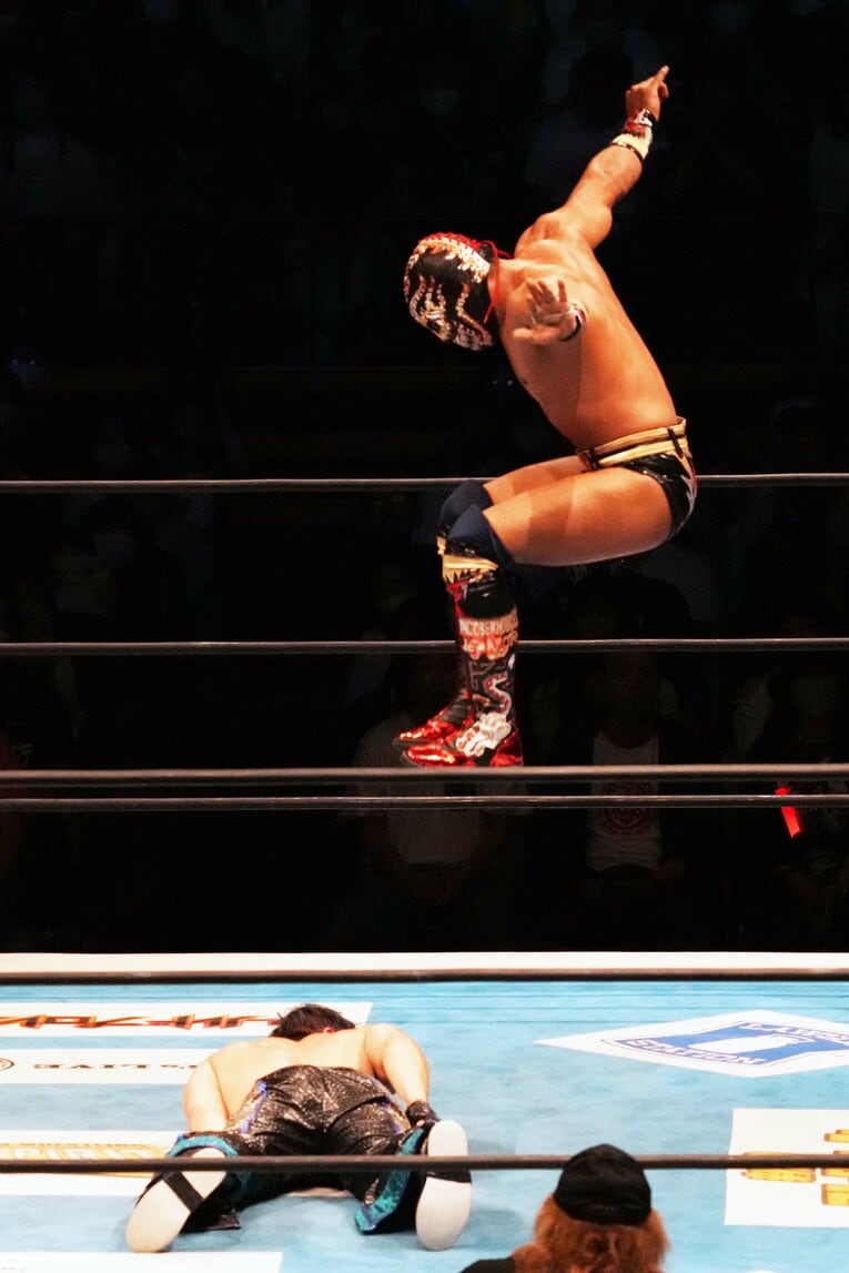 コーナーからワトの背中を踏みつけにいくティタン