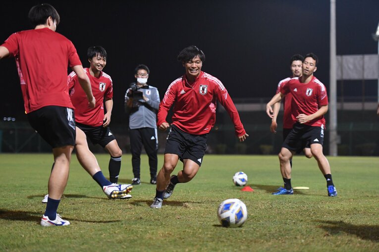 笑顔でボールを追いかける旗手怜央　©JFA