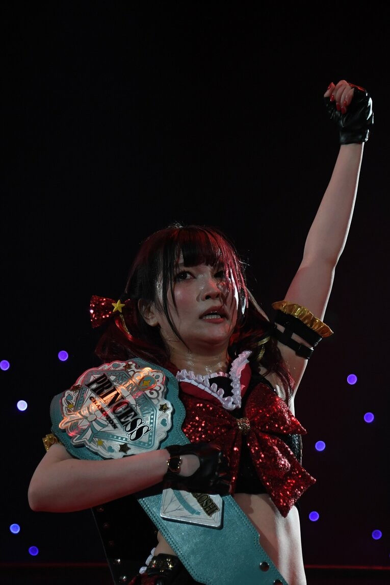 ベルトを肩にかけ、拳を突き上げる伊藤麻希