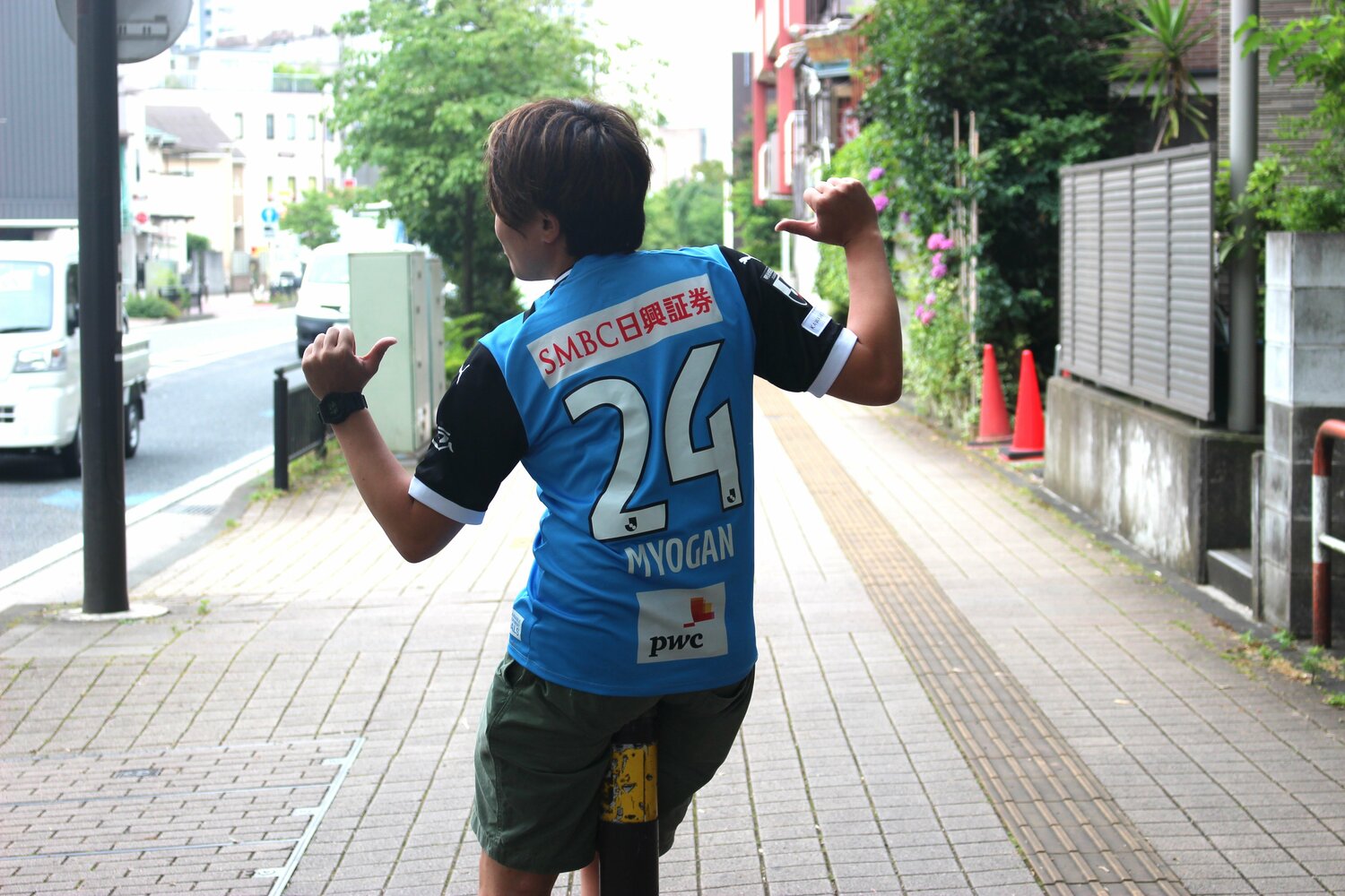 名願斗哉のユニフォームを着て取材に応じる小野田治矢さん ©Number Web