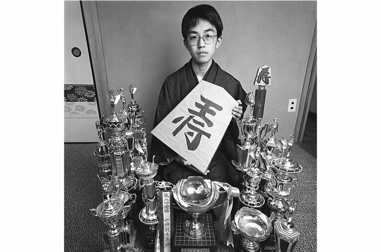 文藝春秋が当時発行していた漫画誌インタビューでの1枚。すでに手にしていたタイトルのトロフィーとともに“王将”の駒を持ってくれるサービス精神も。 ／ photograph by Hatsuhiko Yoshida