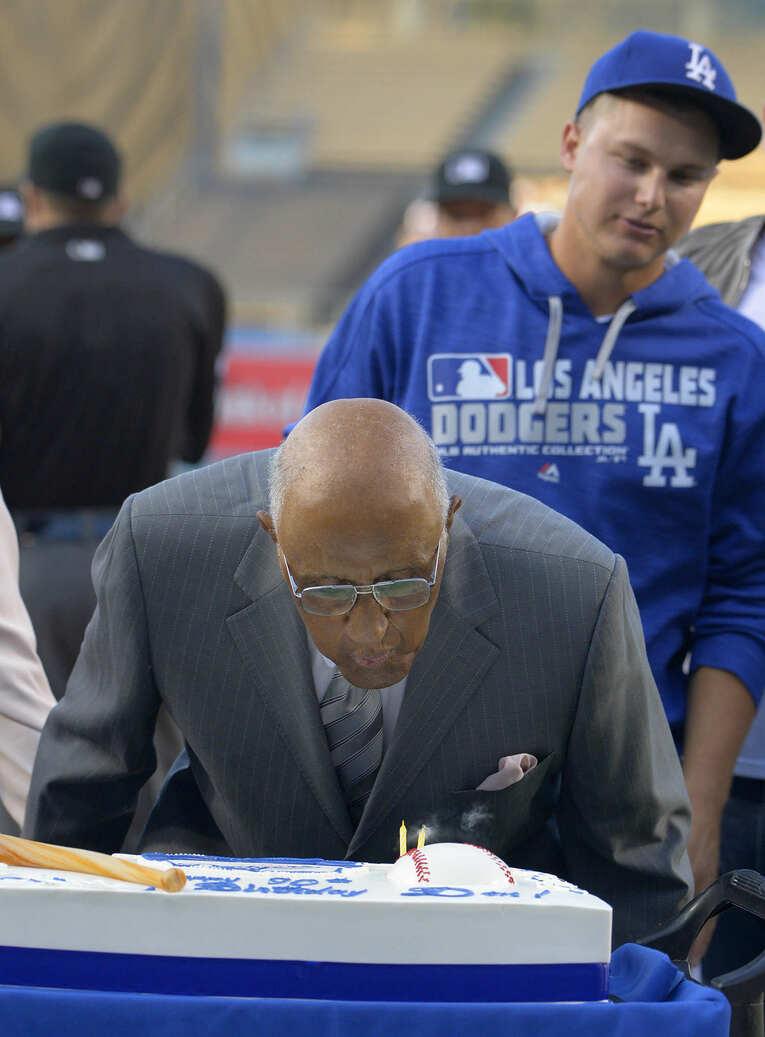 90歳のバースデイケーキのロウソクを消すドン・ニューカム　©︎Getty Images