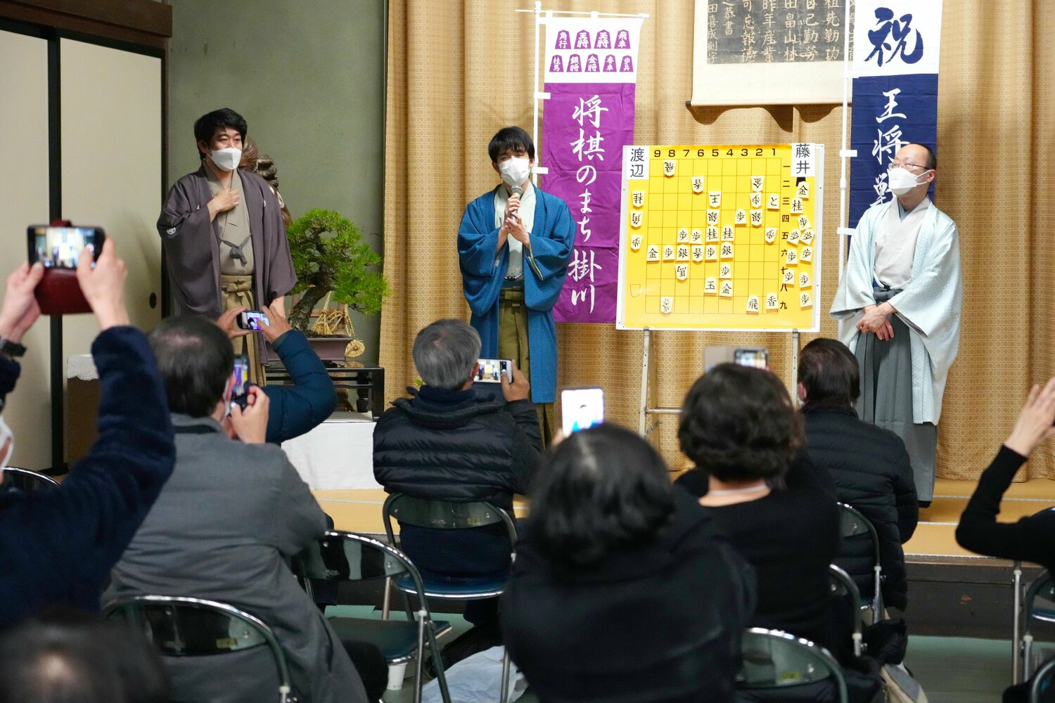 渡辺明王将（右）との対局を終え、大盤解説会場であいさつする藤井聡太竜王（中央） ©JIJI PRESS