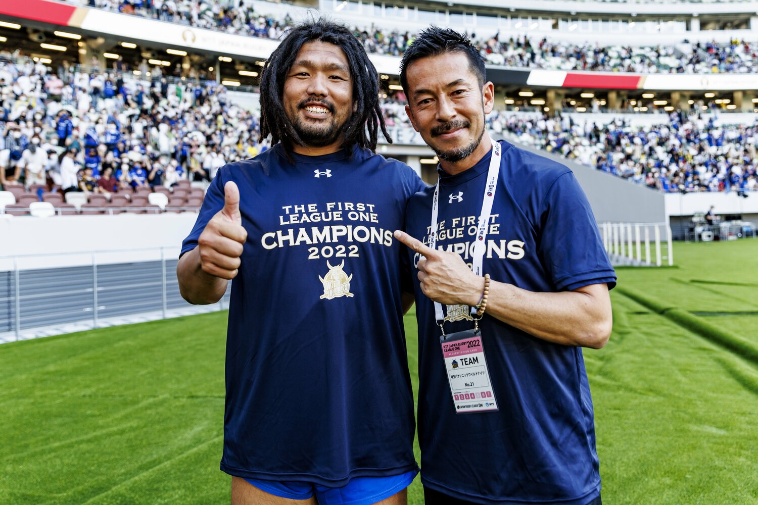 昨季のリーグワン・プレーオフトーナメント決勝を制し、笑顔でポーズをとる堀江翔太と佐藤義人トレーナー　©︎Kiichi Matsumoto