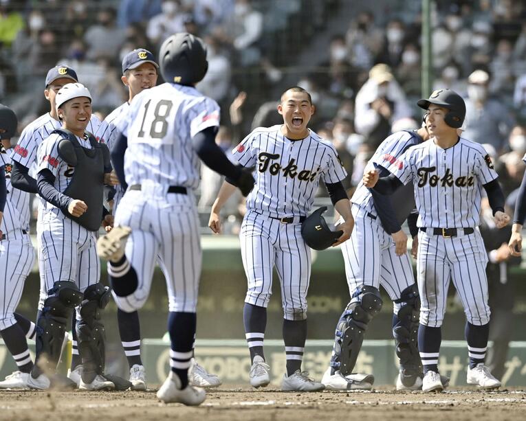 逆転サヨナラ二塁打を放った代打多井耶雲（背番号18）。試合が決したあとも三塁～ホームまで走り続け、それを迎える東海大菅生ナイン　©KYODO