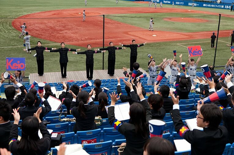 神宮球場での慶應義塾大の応援風景。壇上中央が4年生の時の近藤雄介氏。選手と観客を結びつけるものこそ「応援」であり、「応援歌」である。 ／ photograph by Hirotaka Yokomizo