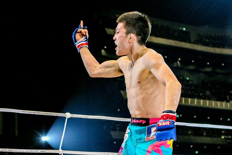 観客に中指を突き立てる青木