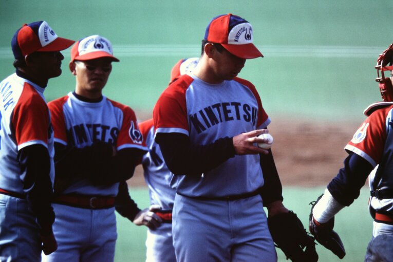 開幕戦で9回のピンチ、コーチがマウンドにやってきて、ボールを見つめる野茂　©Koji Asakura