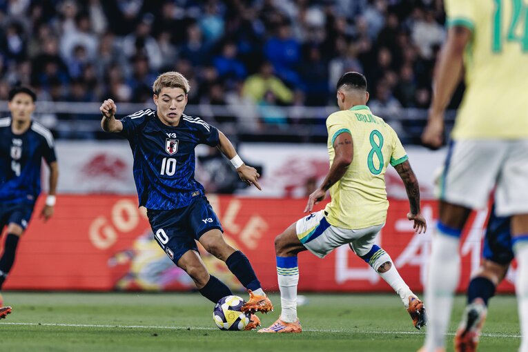 【計30枚超：“テレビに映らない”日本代表ブラジル戦歴史的初勝利】ブラジルのギマランイス相手に臆さず仕掛ける堂安律…写真はまだまだ続きます　©Kiichi Matsumoto