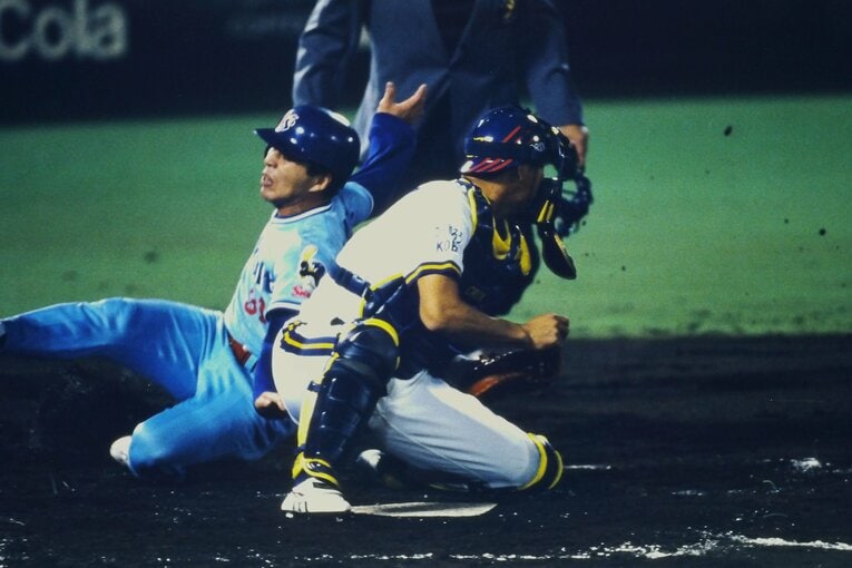 【連続写真3/8】1995年、オリックスとの日本シリーズで本塁突入する真中。捕手は中嶋聡　©Kazuaki Nishiyama