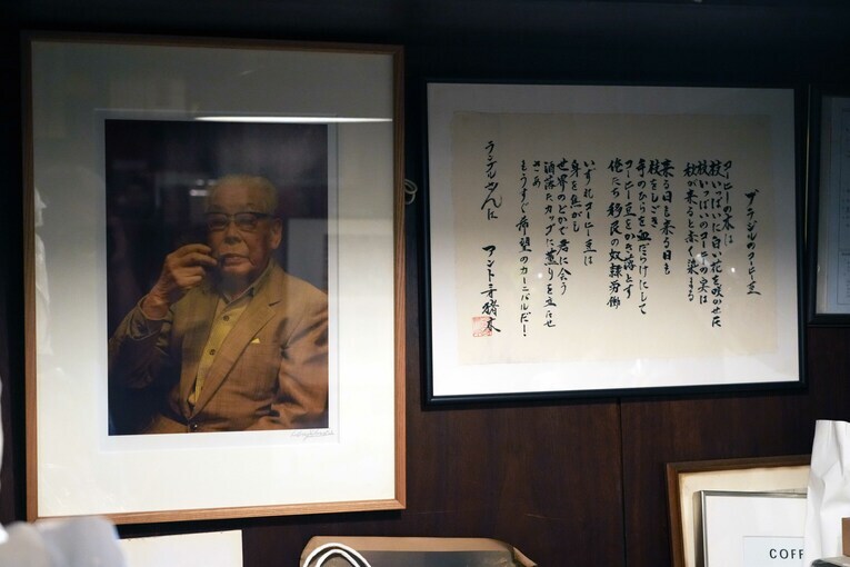 ランブルの創業者・関口一郎さんの写真とアントニオ猪木が書した「ブラジルのコーヒー豆」の詩　©Essei Hara