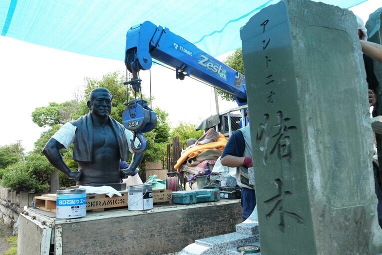 135キロある猪木ブロンズ像はクレーンで両腕をつられて墓に設置される