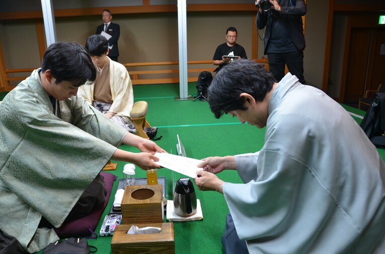 封じ手を立会人の森内俊之九段に渡す　©日本将棋連盟