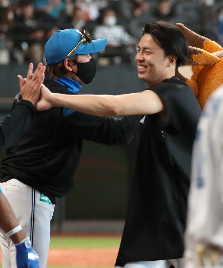 プロ初勝利をあげて新庄剛志監督に迎えられた田中　©︎SANKEI SHIMBUN